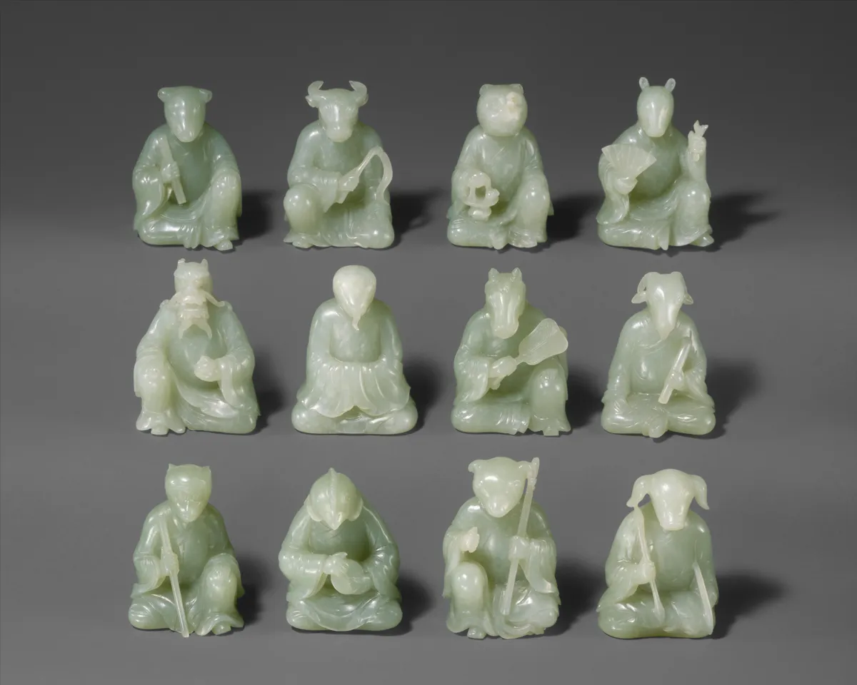 Douze petites figurines en jade des animaux du zodiaque chinois : des personnages assis à tête d'animal, sur trois rangs
