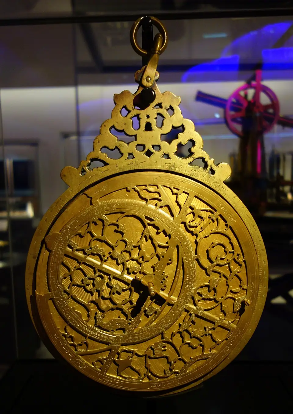 Ein Astrolabium aus Messing mit durchbrochener, verzierter Platte und einem Zeiger in einer Museumsvitrine