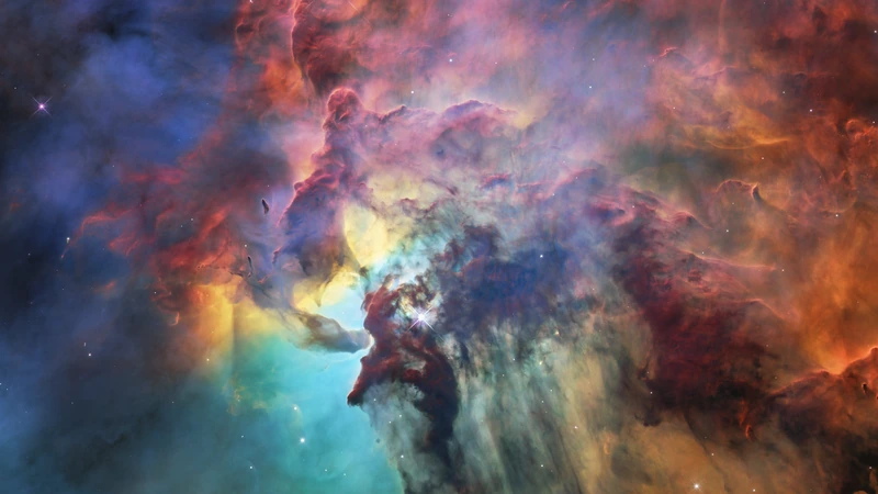 Colorful clouds of gas and dust in blue, green, red and yellow at the center of the Lagoon Nebula.