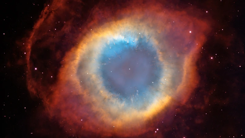 The Helix Nebula: a ring of blue, yellow and orange gas with a red outer edge, like an eye.