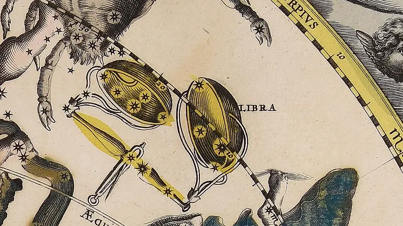 Deux plateaux de balance jaunes sur un fléau, avec des étoiles dans les plateaux, à côté de l'inscription Libra.